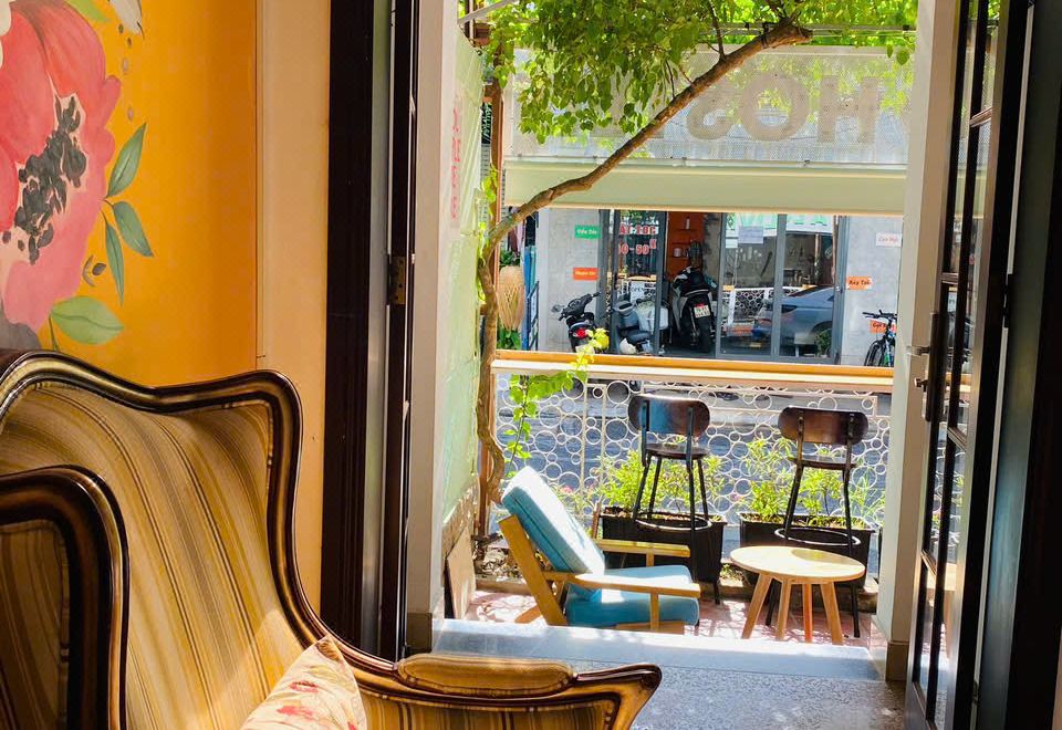 A small balcony seating area overlooking the street, with a wooden bench and chairs