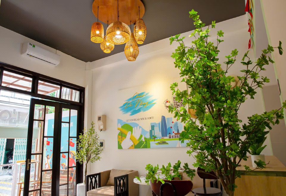 Common room with rattan pendant lamps and a Da Nang welcome mural