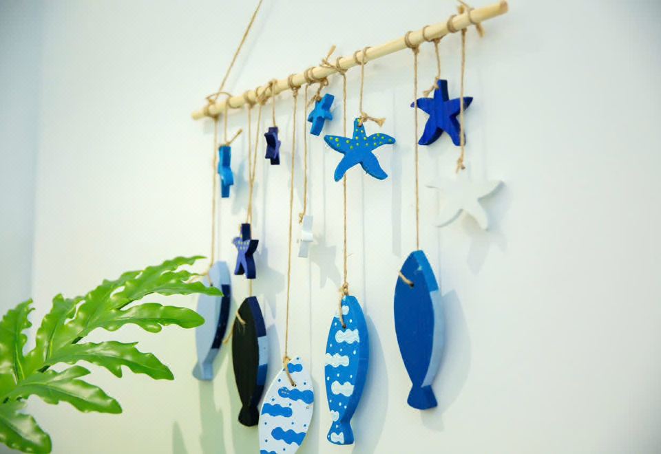 Hand-painted wooden fish and starfish decorations on a wall