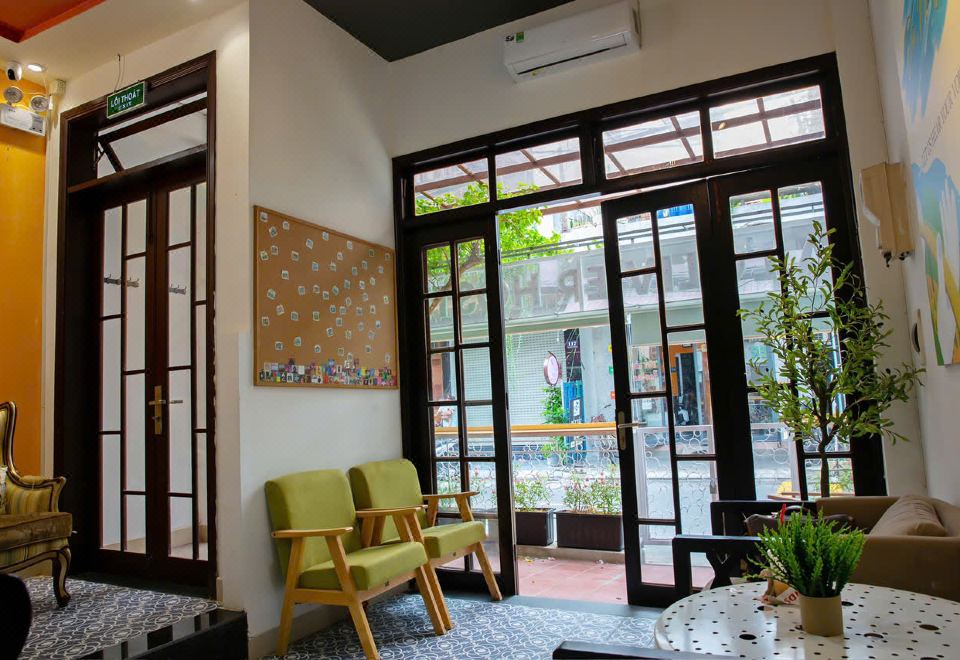 Lounge area near the entrance with green armchairs and plants