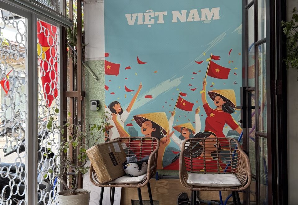 A reading nook with rattan chairs against a Vietnam-themed mural