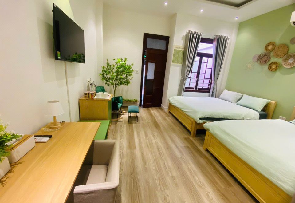 A private room with two queen beds, TV, desk and air conditioning